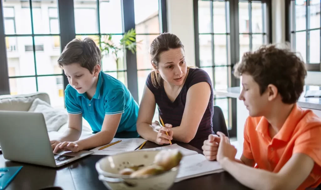 Mother Helping Her Two Sons with Their School Work at Home