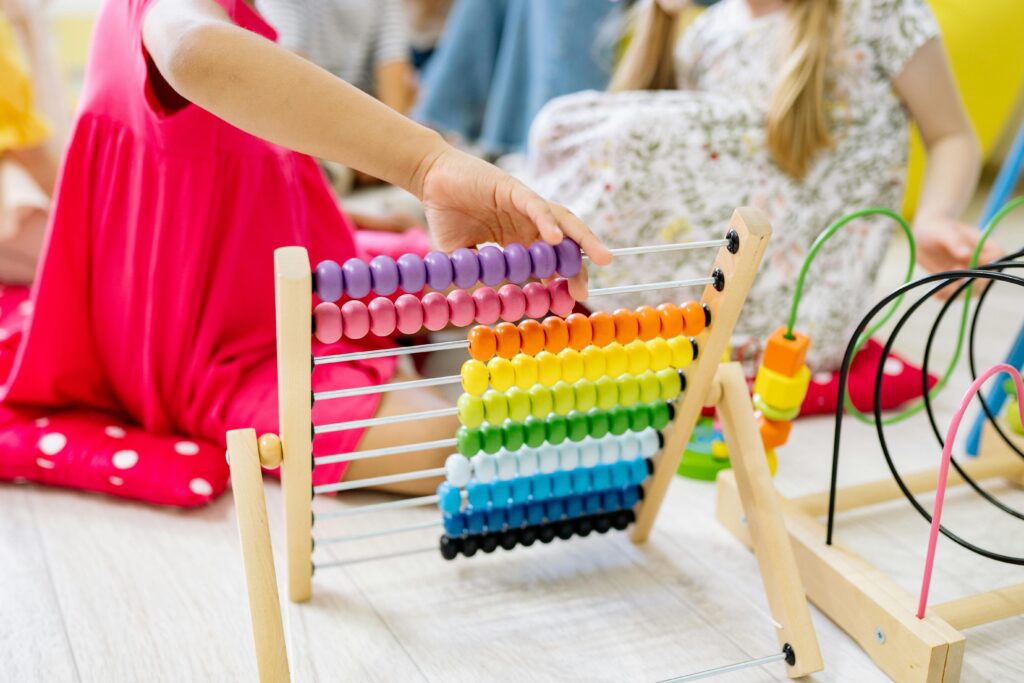 Girl Moving Beads on a Colorful Abacus