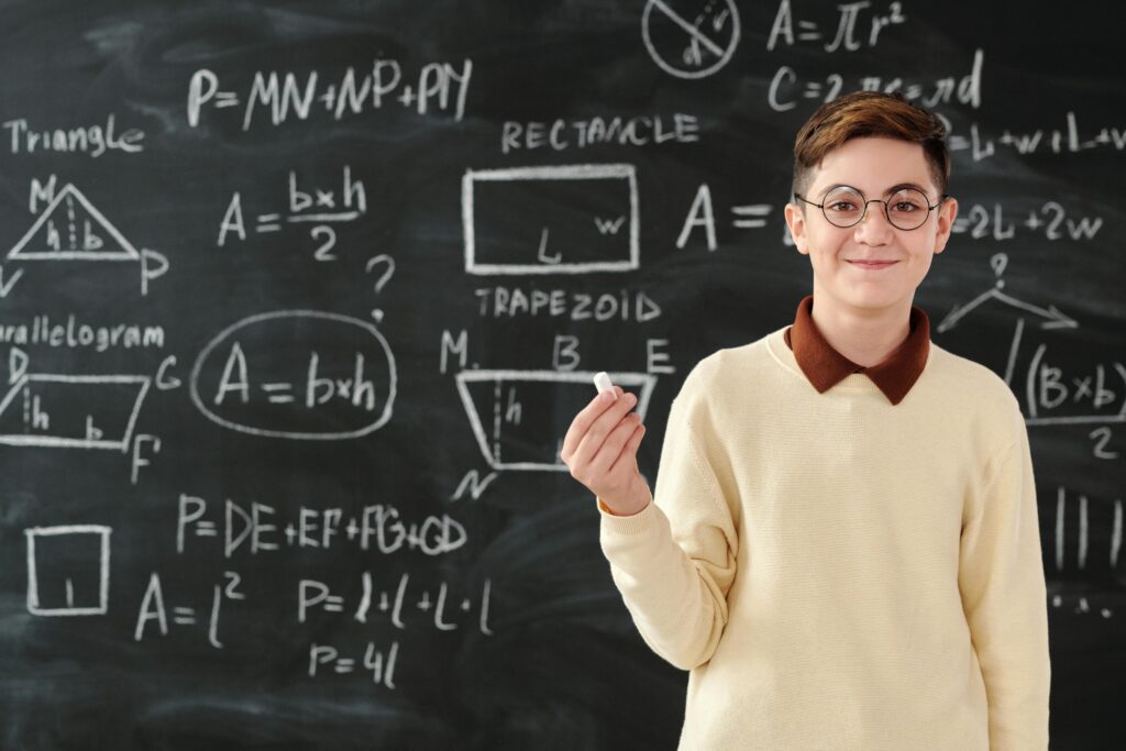 Preteen Boy Displaying Algebra Problems on a Chalk Board