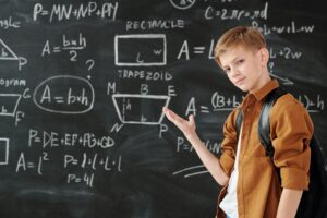 Preteen Boy Displaying Algebra Problems on a Chalk Board