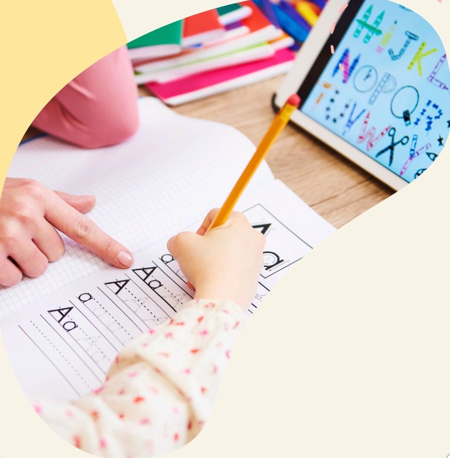 Young Girl Tracing the Letter A on a Worksheet