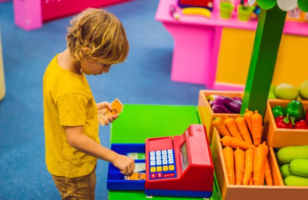 Young Boy Using a Toy Cash Register