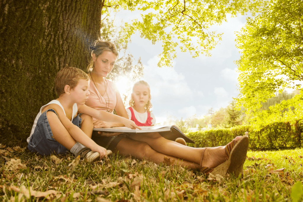 Mother Reading a Picture Book Under a Shade Tree