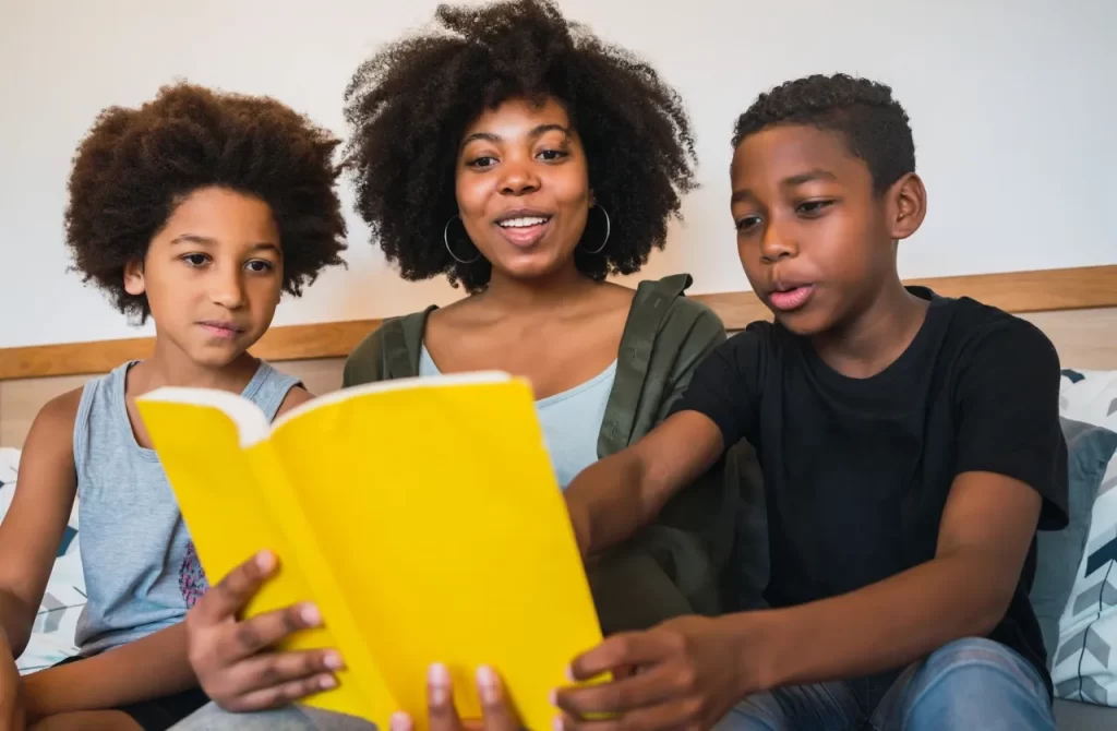 A mother reading a book to her two sons