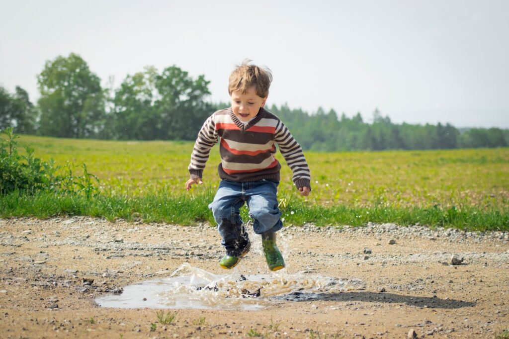 Boy jumping in a puddle